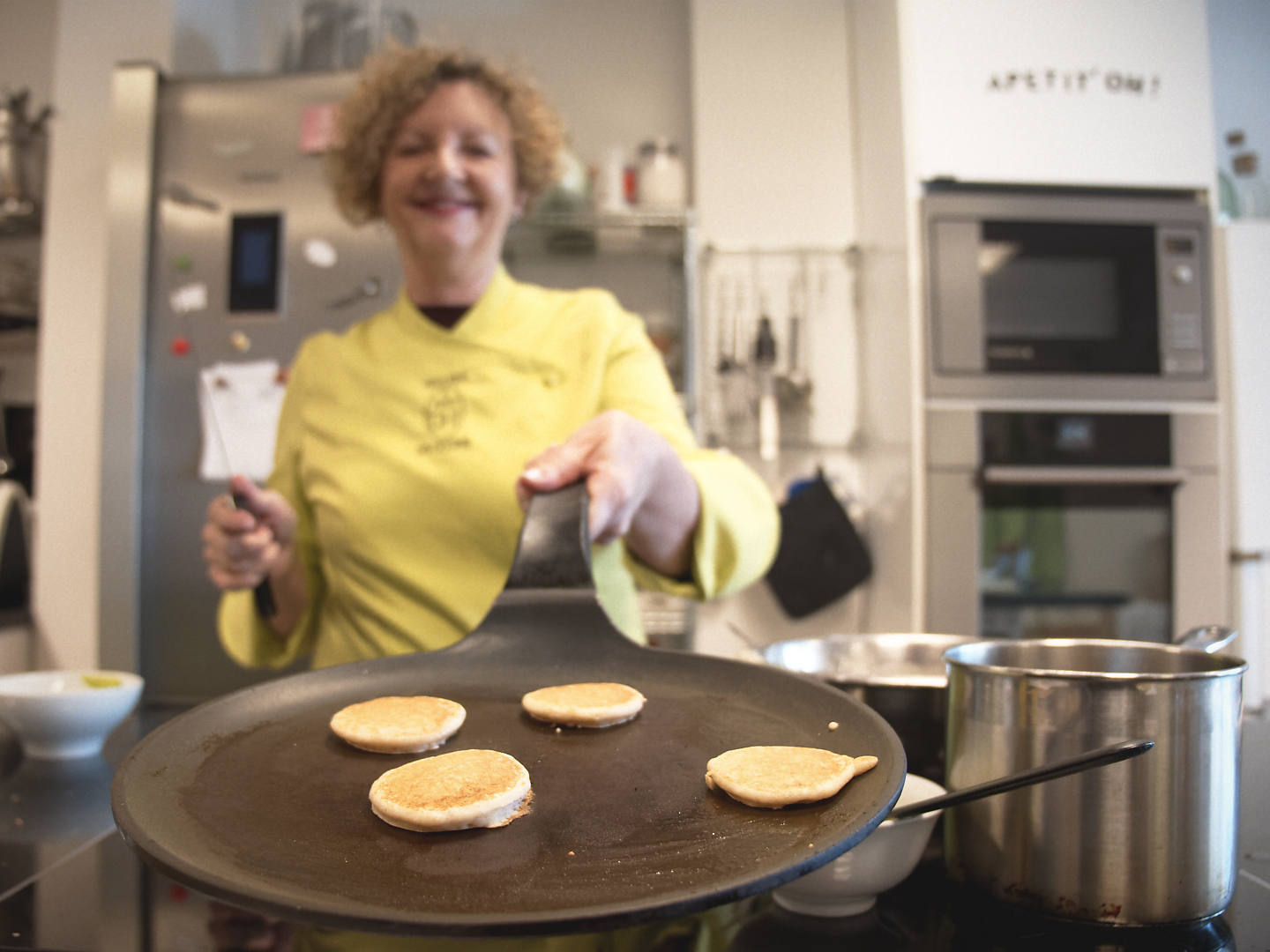 Sartén con mini tortitas en un taller de cocina durante un documental gastronómico.